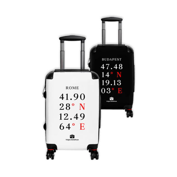 Dos maletas de viaje con ruedas y asa extensible, una blanca y otra negra, personalizadas con coordenadas de ciudades en tipografía elegante.