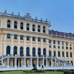 Fachada del Palacio de Schönbrunn en Viena, Austria, con cielo azul al atardecer.